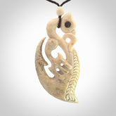 Whalebone double manaia pendant with paua shell, hand carved in New Zealand for NZ Pacific. Maori design pendant for sale online.