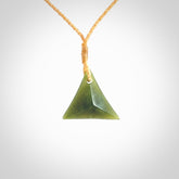 This is a lovely New Zealand Jade, pounamu triangle drop pendant. Hand carved for us by Ric Moor. It is bound with an adjustable beige coloured cord which is length adjustable. Free worldwide shipping.