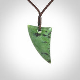 This is a lovely New Zealand Jade, pounamu niho drop pendant. Hand carved for us by Ric Moor. It is bound with an adjustable brown coloured cord which is length adjustable. Free worldwide shipping.