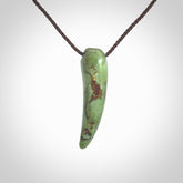 This is a lovely New Zealand Jade, pounamu niho drop pendant. Hand carved for us by Ric Moor. It is bound with an adjustable brown coloured cord which is length adjustable. Free worldwide shipping.