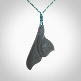 Hand carved New Zealand Argillite Stone whale tail pendant by Rueben Tipene. Hand made art to wear for lovers of the ocean. Delivered with express courier and delivered to you on an adjustable cord.