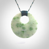 Hand carved by Rueben Tipene, this lovely Jadeite pendant is hand made and an absolute delight. One pendant only, postage is included in the price. One White Siberian Jade pendant. White Siberian Jadeite oval disc pendant. Perfect gift for someone special. The shape of the pendant is a disc form.