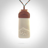 A hand carved bone toki with NZ Pacific logo engraving. Unique hand made jewellery from New Zealand Pacific.