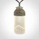 A hand carved bone toki with NZ Pacific logo engraving. Unique hand made jewellery from New Zealand Pacific.