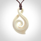 Hand carved twist with koru. Made from natural bone by NZ Pacific. Delivered with an adjustable cord.
