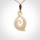 Hand carved twist with koru. Made from natural bone by NZ Pacific. Delivered with an adjustable cord.
