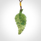 A delicate green jade fern leaf pendant with an adjustable neck cord. Green stone fern leaf necklace with adjustable cord. Delivery included.