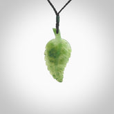 A delicate green jade fern leaf pendant with an adjustable neck cord. Green stone fern leaf necklace with adjustable cord. Delivery included.