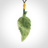 A delicate green jade fern leaf pendant with an adjustable neck cord. Green stone fern leaf necklace with adjustable cord. Delivery included.