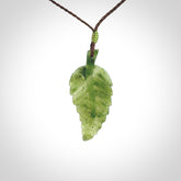A delicate green jade fern leaf pendant with an adjustable neck cord. Green stone fern leaf necklace with adjustable cord. Delivery included.
