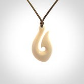 A fish hook necklace (hei-matau) hand-carved in a traditional style from Woolly Mammoth Tusk. These are glorious pieces of art to wear. Provided with adjustable cords and packaged in a woven kete pouch