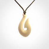 A fish hook necklace (hei-matau) hand-carved in a traditional style from Woolly Mammoth Tusk. These are glorious pieces of art to wear. Provided with adjustable cords and packaged in a woven kete pouch