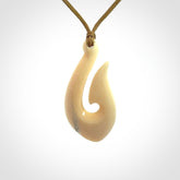 A fish hook necklace (hei-matau) hand-carved in a traditional style from Woolly Mammoth Tusk. These are glorious pieces of art to wear. Provided with adjustable cords and packaged in a woven kete pouch