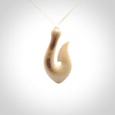 A fish hook necklace (hei-matau) hand-carved in a traditional style from Woolly Mammoth Tusk. These are glorious pieces of art to wear. Provided with adjustable cords and packaged in a woven kete pouch. Delivered with express courier.
