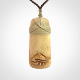 A hand carved bone toki pendant with NZ Pacific logo engraving. These have been stained with our home made tea dye. Unique hand made jewellery from New Zealand Pacific.