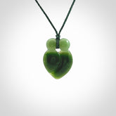This picture shows a stylised couple in a close embrace sharing a kiss. The pendant is hand carved from a bright faultless piece of British Columbian jade. The cord is a 3-ply plaited green which is adjustable.