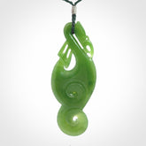 This pendant is a beautiful large New Zealand Auhunga green jade manaia pendant with koru. It has the head of a bird and the tail of a fish and also two koru carved into the body. It is carved by Ross Crump here in New Zealand. Provided with an adjustable manuka green cord.