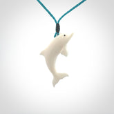 Hand made Bone dolphin pendant carved for men and women. Hand carved Bone dolphin with adjustable cord. Gifts for lovers of dolphins and art to wear. Free delivery worldwide.