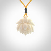 This is a hand carved lotus flower pendant. It is made from bone. This is a medium sized necklace and is a very unique pendant and is a wonderful necklace to wear. Hand carved bone lotus flower pendant with adjustable cord.