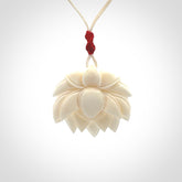 This is a hand carved lotus flower pendant. It is made from bone. This is a medium sized necklace and is a very unique pendant and is a wonderful necklace to wear. Hand carved bone lotus flower pendant with adjustable cord.