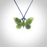 Small Butterfly design pendant carved in nephrite jade. Real jade jewellery for sale online with NZ Pacific. Small butterfly pendant hand made in Jade, provided with pacific blue cord and packaged in a woven kete pouch.