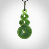 Ross Crump triple twist with koru pendant. Hand carved from rare New Zealand jade this is a beautiful pounamu pendant. The cord is length adjustable. It is a delicate and very beautiful greenstone pendant. For sale online by NZ Pacific.