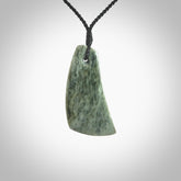 A hand carved curved contemporary drop pendant. This is a piece of genuine jade jewellery, hand carved by Raegan Bregmen. He has used rare New Zealand jade and has utilised his experience and carving skill to highlight the natural beauty of the stone. Delivered worldwide, postage is included in the price.
