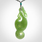 This pendant is a beautiful large New Zealand Inanga jade manaia pendant with koru. It has the head of a bird and the tail of a fish and also two koru carved into the body. It is carved by Ross Crump here in New Zealand. Provided with an adjustable Grey cord.