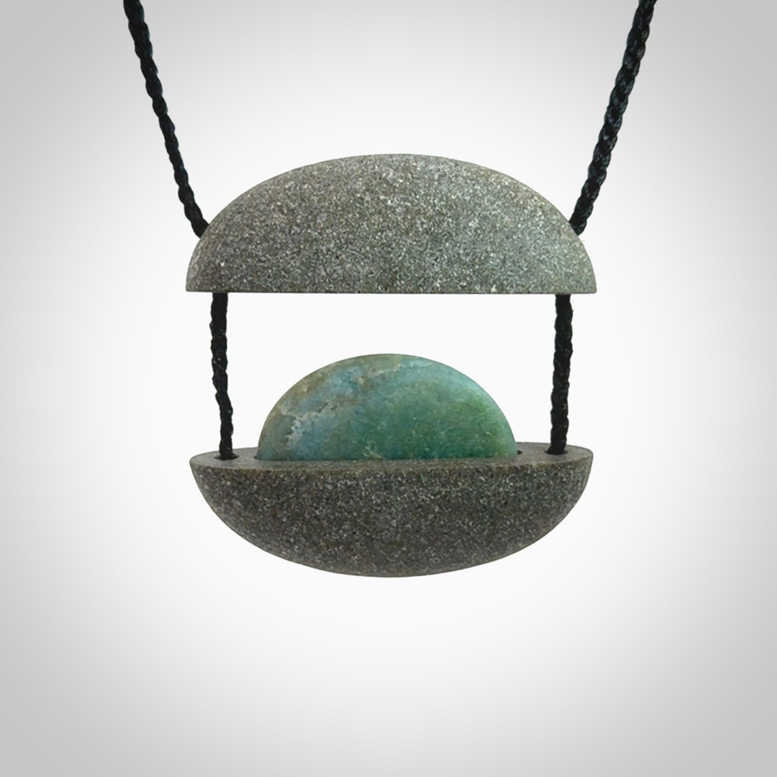 Greywacke stone pendant with Aotea Stone insert. Hand carved by Rhys Hall for NZ Pacific. Handmade contemporary jewellery for sale online.