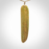 Raukaraka Pounamu drop pendant. Hand carved by Rhys Hall for NZ Pacific. Handmade jewellery for sale online. The cord is a 3-braid plait in tan and has a loop and pebble toggle closure. Drop necklace for men and women. Large drop necklace hand made from New Zealand Jade.