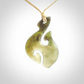 This photo shows a hook with koru pendant carved from New Zealand Jade. We provide this piece with an adjustable oat cord.