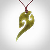 This photo shows a koru pendant carved from New Zealand Jade. We provide this piece with an adjustable plum cord.