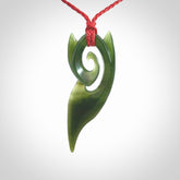 This photo shows a koru pendant carved from New Zealand Jade. The artist, Shaun Gardiner, has carved this beautifully. We provide this piece with an adjustable red cord. This is a fantastic work of art, we have one only.
