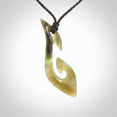 This photo shows a large contemporary matau pendant carved from New Zealand Jade. The artist, Shaun Gardiner, has carved this beautifully. We provide this piece with an adjustable dark brown coloured cord. This is a fantastic work of art, we have one only.