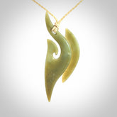 This photo shows a matau pendant carved from New Zealand Pounamu, Jade. The artist, Shaun Gardiner, has carved this beautifully. We provide this piece with an adjustable oat coloured cord. This is a fantastic work of art, we have one only.