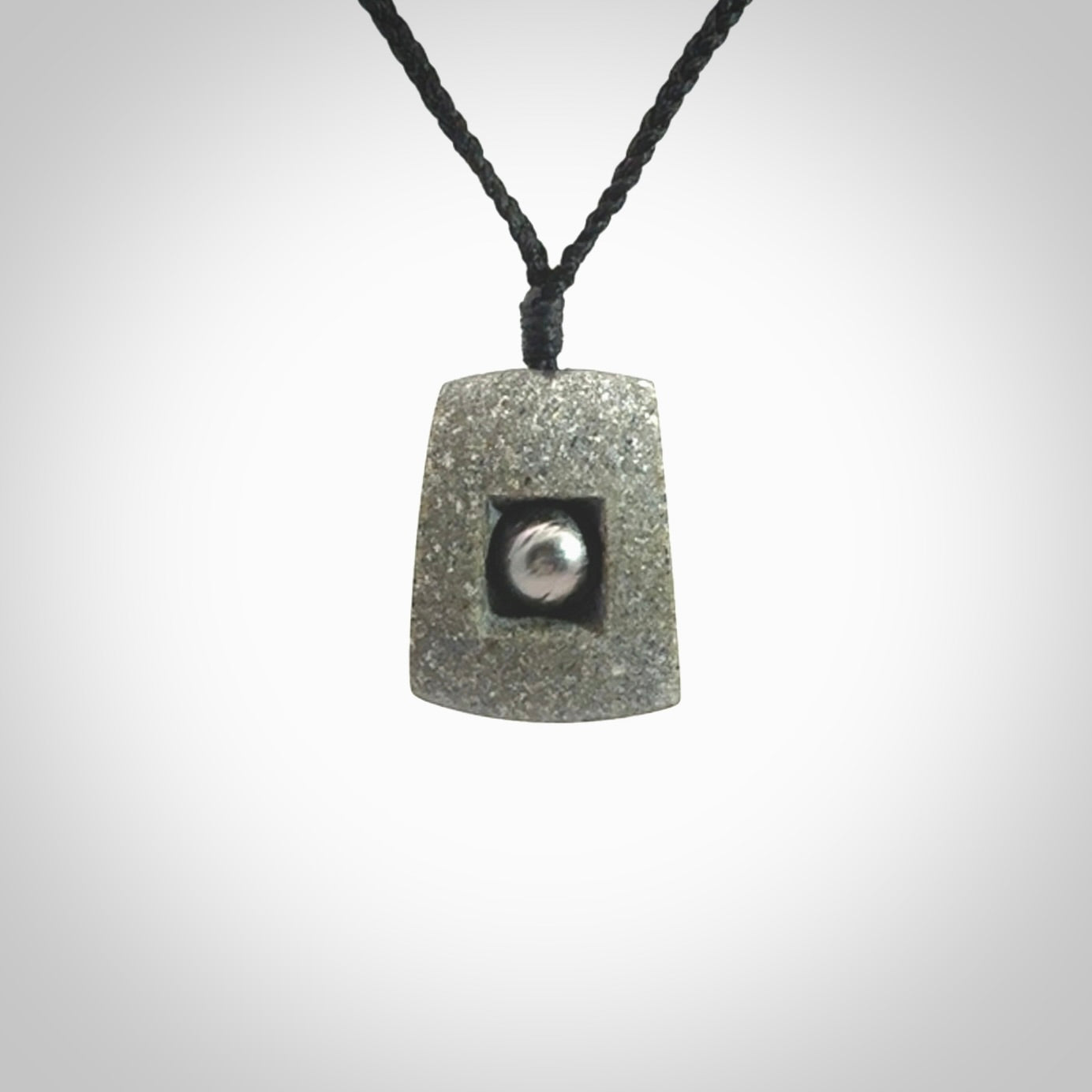 Greywacke stone pendant with Black Pearl insert. Hand carved by Rhys Hall for NZ Pacific. Handmade contemporary jewellery for sale online.