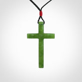 Hand carved jade cross. Made from New Zealand jade. Christian cross for sale online.This picture shows a green jade cross suspended on a fine, plaited cord. The cross is hand carved jade cross. Made from New Zealand jade. Christian cross for sale online.