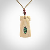 A stunning hand carved Woolly Mammoth Tusk Toki pendant. The toki has a small oval shaped piece of Pāua shell inset into the front face. This piece is bound with an adjustable cord. This is a little piece of Art to wear.