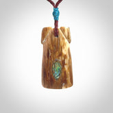 A stunning hand carved Woolly Mammoth Tusk Toki pendant. The toki has a small oval shaped piece of Pāua shell inset into the front face. This piece is bound with an adjustable cord. This is a little piece of Art to wear.
