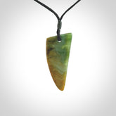 This photo shows a medium jade drop shaped pendant. It a a lovely varied green and orange New Zealand Marsden jade. The cord is black and is adjustable in length. One only medium, contemporary drop necklace from Jade.