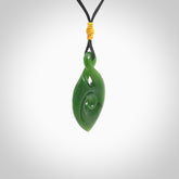 Ross Crump twist with koru pendant. Hand carved from rare New Zealand jade this is a beautiful pounamu pendant. The cord is hand plaited and is length adjustable. It has a little spiral floret popper at the top of the pendant. It is a delicate and very beautiful greenstone pendant. For sale online by NZ Pacific.