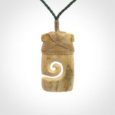 Hand carved Woolly Mammoth Tusk toki with koru pendant. Toki with koru necklace carved from ancient woolly mammoth tusk. Provided with adjustable cord and packaged in a woven kete pouch.
