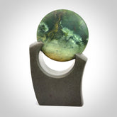 Hand carved New Zealand Marsden Jade Disc with Greywacke stand sculpture. Hand carved here in New Zealand by Ric Moor. This is a 'one only' sculpture, a beautiful display piece.