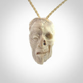 This photo shows a mummy skull pendant hand carved in deer antler. It is provided with a plaited cord necklace which is length adjustable.