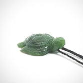 British Columbian jade turtle pendant. Hand carved jade turtle pendant, made by NZ Pacific for sale online. Unique handmade jewellery. Provided with an adjustable cord and packaged in a woven kete pouch.