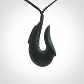 This photo shows a greenstone hook, or matau, pendant. It is a beautiful deep green jade. The cord is plaited and the length can be adjusted.