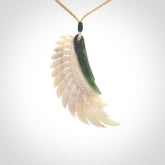 This photo shows a beautiful bone and jade wing pendant.