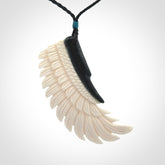 This photo shows a beautiful bone and jade wing pendant.