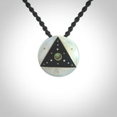This photo shows a triangle disc pendant hand carved from ebony with nz paua shell, Mother of Pearl alongside; brass and silver. This is a stand out one off necklace for those who appreciate art to wear. It is provided with a cord in black that is a fixed length with Paua Shell Toggle. We ship this piece worldwide and shipping is included in the price.