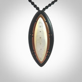 This photo shows a medium sized drop pendant hand carved from ebony with Mother of Pearl inlay alongside; copper and silver. This is a stand out one off necklace for those who appreciate art to wear. It is provided with a cord in black that is a fixed length with Paua Shell Toggle. We ship this piece worldwide and shipping is included in the price.